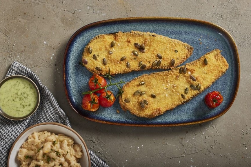 שניצל דלעת וחצילים טבעוני מוגש על פירה שעועית לבנה